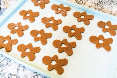Zencefilli kurabiyeler, mükemmel soğutulmuş ve parşömen kağıdıyla kaplı bir kabın üzerine yerleştirilmiş, fırında pişirmek için sıralarını bekliyorlar..