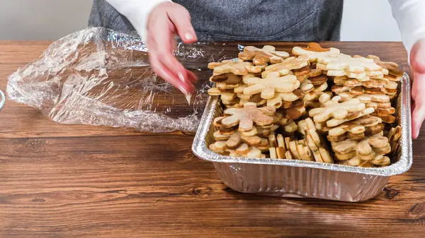 Kar taneleri şeklinde altın renkli kurabiyeler. Karmaşık bir şekilde istiflenmiş..