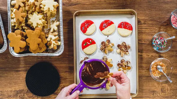 stock image Flat lay. Creating snowflake-shaped cutout sugar cookies, dipped in chocolate, and adorned with different toppings.