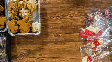 Düz yatıyordu. Dikkatlice paketlenmiş Noel kurabiyeleri, çikolataya batırılmış, ezilmiş fındık serpiştirilmiş, ve şeffaf selofan ambalajla sunulmuş..