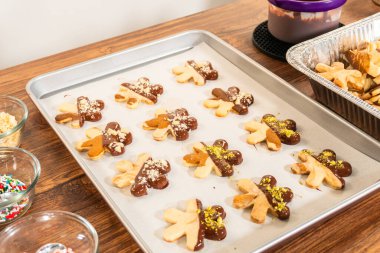 Çikolataya batırılmış yıldız şeklinde tatil kurabiyeleri ve ezilmiş şam fıstığı serpiştirmek. Parşömen kağıdına yerleştirilmiş..