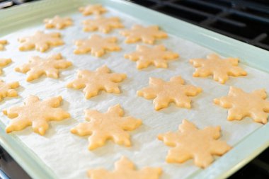 Lezzetli kar tanesi şeklindeki kurabiyeleri pişirdikten sonra soğutarak onları Noel hediyelerine hazırlamak..