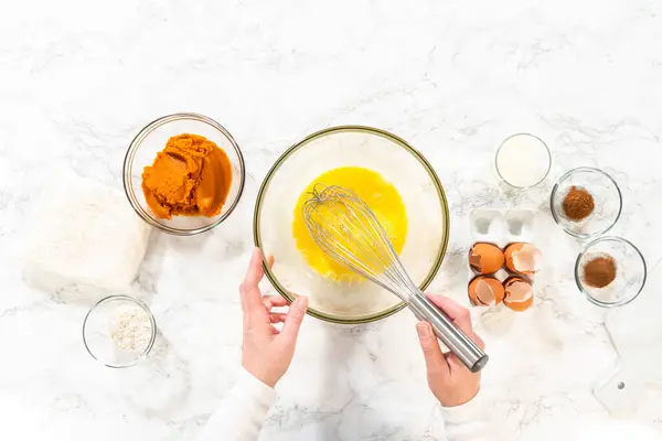 stock image Flat lay. In a cozy kitchen, a large mixing bowl becomes the stage for expertly blending the ingredients, setting the scene for crafting a delightful homemade pumpkin bundt cake from cake mix.