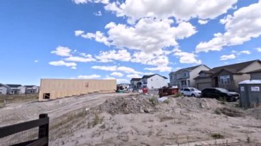 Denver, Colorado, ABD-30 Ağustos 2023-Timelapse yeni bir yerleşim yerinin ham ahşap çerçeve ve tamamlanmış evler arasındaki katı zıtlığı ortaya koyuyor