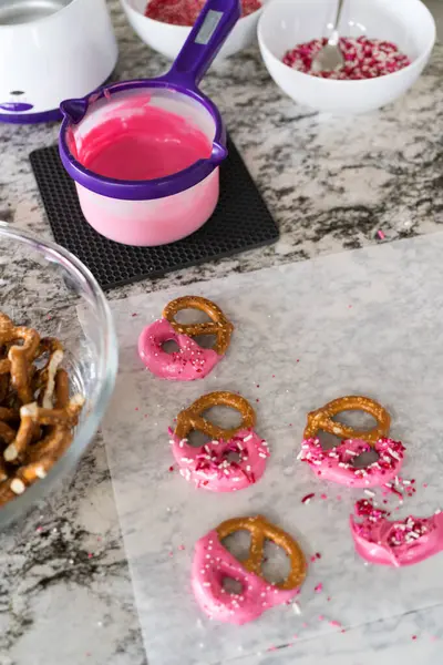 stock image Freshly dipped and still glistening, these crunchy pretzels are lovingly adorned with pink chocolate and a scattering of colorful sprinkles, promising a feast for the senses.