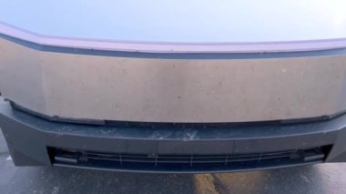 Santa Fe, New Mexico, ABD-31 Mayıs 2024-Slow motion-A Tesla Cybertruck açık hava şarj istasyonundaki bir Tesla Supercharger 'a bağlı. Siber kamyonun parlak, açısal tasarımı...