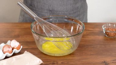 Bardak karıştırma kabında, büyük bir el çırpma ustalıkla lezzetli zencefilli kek ve karamel kremalı pasta malzemelerini karıştırır..