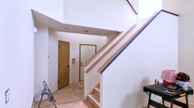 Süpürge, Colorado, ABD-12 Mayıs 2024-Ağır çekim-A merdiveni koruma amaçlı koruyucu örtüler ve maskeleme bantlarıyla yenilenen bir evde. Bölge boyamaya hazır.