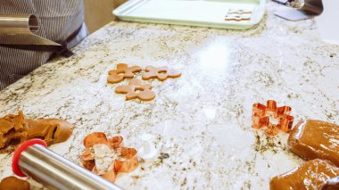 Çeşitli şenlikli kurabiye kesicilerle mermer tezgahtaki rulo hamurdan sevimli zencefilli kurabiyeler kesip modern mutfağa bayram neşesi getiriyorduk..