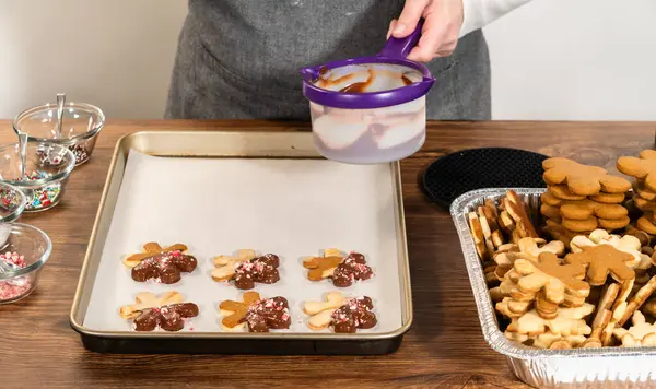 stock image Preparing star-shaped cookies, half-dipped in chocolate, accented with peppermint chocolate chips for the holidays.