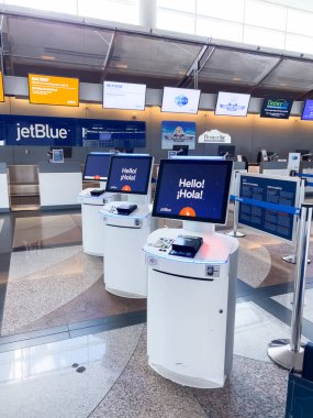 Denver, Colorado, ABD-15 Ağustos 2024-A view of self-check-in kiosks at Denver International Airport DIA, with JetBlue Airlines markalı. Büfeler terminalde, parlak bir şekilde kurulmuş.