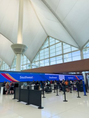 Denver, Colorado, USA-August 15, 2024-A wide-angle shot of the interior at Denver International Airport DIA, showcasing multiple levels of the terminal under the iconic tented roof. The upper level clipart