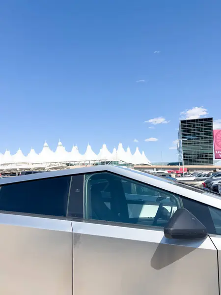 stock image Denver, Colorado, USA-August 15, 2024-A side view of a Tesla Cybertruck parked at Denver International Airport, DIA in Denver, Colorado. The futuristic vehicle stands out in the parking lot, with the