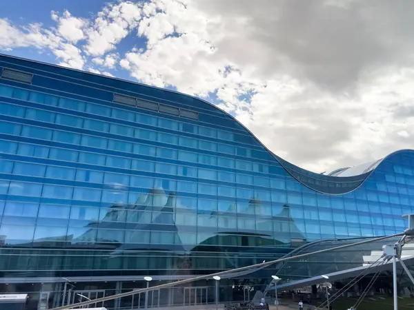 stock image Denver, Colorado, USA-August 15, 2024-A striking view of the curved glass facade of the hotel located at Denver International Airport DIA. The modern architecture features reflective blue glass