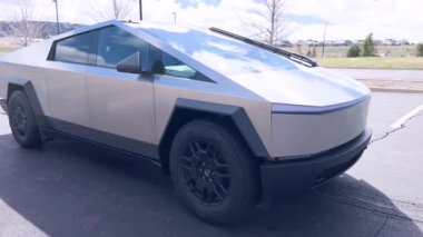 Denver, Colorado, ABD-28 Nisan 2024 Tesla Siber Kamyonu burada boş bir otoparkta, bulutlu bir gökyüzünün altında eşsiz açısal ve metalik şeklini vurgulayarak ele geçirildi.