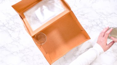 Düz yatıyordu. Elleri titizlikle bir kaseye taze kırmızı üzüm ekliyor. Şarküteri kutusuna çeşitli peynirler, zeytinler ve pişirilmiş etler dolduruluyor.