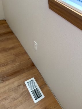 Yeni monte edilmiş vinil döşeme sergilenen boş bir oda. Alan yenileniyor, camları koruyucu bant ve tarafsız duvarlarla kaplı. Manzara bir koridordan geliyor.