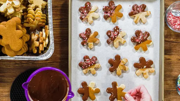 stock image Flat lay. Creating snowflake-shaped cutout sugar cookies, dipped in chocolate, and adorned with different toppings.