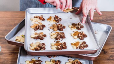 Dikkatlice paketlenmiş Noel kurabiyeleri, çikolataya batırılmış ve şeffaf selofan ambalajla sunulmuş, bayram hediyesi olarak mükemmel..