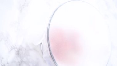 Çilekler, yeni yıkanmış ve kurutulmuş, cam bir kasede güzelce depolanmış kağıt havluyla kaplanmış ve tazeliği korumak için plastikle kaplanmış..