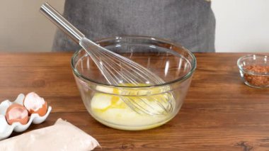 Bardak karıştırma kabında, büyük bir el çırpma ustalıkla lezzetli zencefilli kek ve karamel kremalı pasta malzemelerini karıştırır..