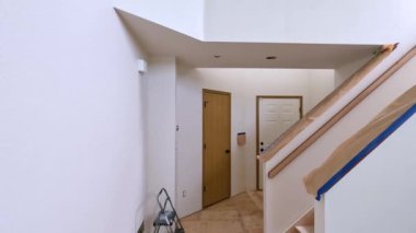 Süpürge, Colorado, ABD-12 Mayıs 2024-Ağır çekim-A merdiveni koruma amaçlı koruyucu örtüler ve maskeleme bantlarıyla yenilenen bir evde. Bölge boyamaya hazır.