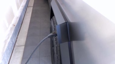 Denver, Colorado, ABD-28 Nisan 2024. Tesla Cybertruck 'ın şarj edildiği yakın çekim görüntüsü. Araç portuna bağlı şarj kablosu.