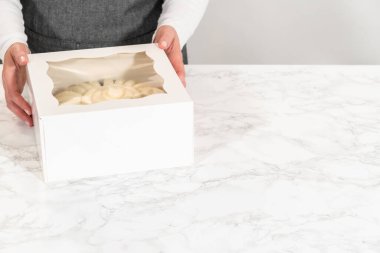 Dikkatli bir şekilde, çikolatalı kek beyaz bir karton kutunun içine paketlenir. Özel birine neşe ve hoşgörü getirmesi için hediye edilir..