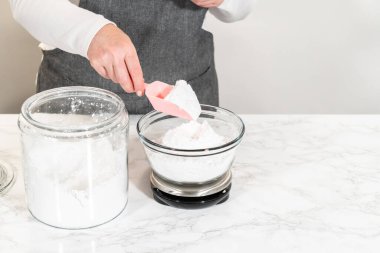 Ev yapımı krem peynir kreması için, pudra şekerini dikkatlice ölçmek zaruridir, tatlılığın ve kremalı dokuların mükemmel dengesini sağlar..