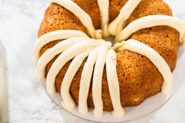 Yeni pişmiş havuçlu kek nefis bir krem peynirli krema tabakasıyla güzelce dondurulmuş..