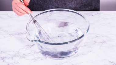 İçi su dolu geniş bir cam karıştırma kabı olgun çilekleri nazikçe temizlemek için hazır bekliyor. Kurumadan ya da depolamadan önce el değmemiş olduklarından emin olmak için..