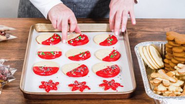 Dikkatlice paketlenmiş Noel kurabiyeleri, çikolataya batırılmış ve şeffaf selofan ambalajla sunulmuş, bayram hediyesi olarak mükemmel..