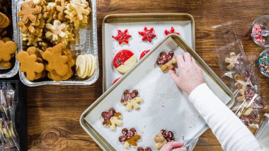 Düz yatıyordu. Dikkatlice paketlenmiş Noel kurabiyeleri, çikolataya batırılmış, ezilmiş fındık serpiştirilmiş, ve şeffaf selofan ambalajla sunulmuş..