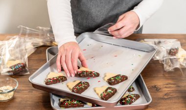 Dikkatlice paketlenmiş Noel kurabiyeleri, çikolataya batırılmış ve şeffaf selofan ambalajla sunulmuş, bayram hediyesi olarak mükemmel..