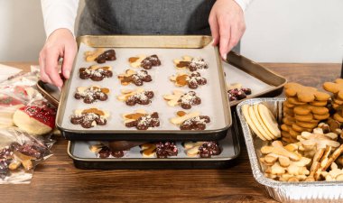 Dikkatlice paketlenmiş Noel kurabiyeleri, çikolataya batırılmış ve şeffaf selofan ambalajla sunulmuş, bayram hediyesi olarak mükemmel..