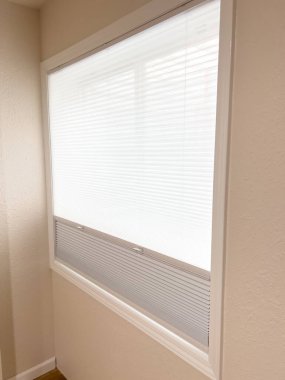 Renovated Room 'da çift hücreli jaluzili beyaz pencere. Yüksek kalite fotoğraf. Yeni yenilenmiş bir odanın penceresinin yakın çekimi. Modern çift hücreli jaluziler var. Panjurlar kısmen açık.