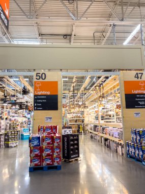 Broomfield, Colorado, ABD-22 Eylül 2024 - Bir hırdavatçı dükkanının ışıklandırma koridorunda tavan vantilatörleri, lambalar ve çeşitli ışıklandırma seçenekleri sergileniyor. Parlak endüstriyel aydınlatma rafları aydınlatıyor