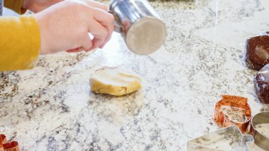 Modern bir mutfaktaki zarif mermer tezgahın üzerine zencefilli kurabiye hamuru sermek için ayarlanabilir bir merdane kullanmak, bayram pişirme şenliğine hazırlanmak....