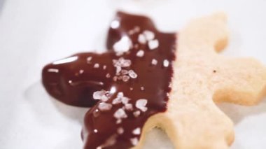 Çikolataya kısmen batırılmış ve fındık parçalarıyla kaplanmış, parşömen kağıdına yerleştirilmiş kesme şekerli kurabiyeler yaratmak..