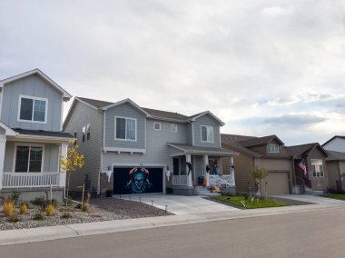 Castle Rock, Colorado, USA-October 12, 2024-A modern home with a decorated front porch for Halloween, featuring bats on the wall, pumpkins, and themed cushions. The house has a black-and-white clipart