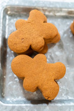 Zencefilli kurabiyeler, kalp şeklinde kesilmiş zencefilli bir adam, mermer bir tezgahın karşısında kırsal metal bir tepside dinleniyor..