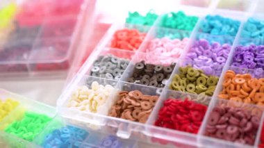 Renklere göre sıralanmış çeşitli kil boncukların yakın plan çekimleri, her boncuğu el yapımı ve mücevher yapımında eşsiz kılan desenleri ve desenleri vurguluyor..