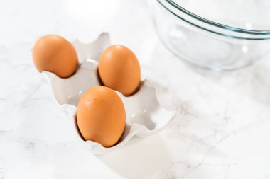 Mutfak tezgahında, çikolatalı kekler yapmak için gerekli malzemeler var. Kek karışımı ve çikolatalı krema kullanılıyor..