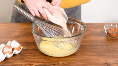 Bardak karıştırma kabında, büyük bir el çırpma ustalıkla lezzetli zencefilli kek ve karamel kremalı pasta malzemelerini karıştırır..