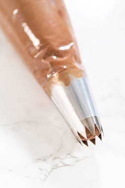 Çikolata kreması özenle bir torbaya aktarılıyor. Lezzetli kekleri süslemeye hazır..