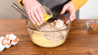 Bardak karıştırma kabında, büyük bir el çırpma ustalıkla lezzetli zencefilli kek ve karamel kremalı pasta malzemelerini karıştırır..