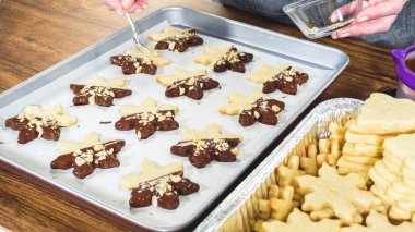 Çikolataya batırılmış ve çeşitli malzemeler serpiştirilmiş yıldız şeklinde tatil kurabiyeleri..