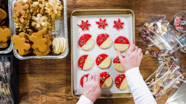 Düz yatıyordu. Dikkatlice paketlenmiş Noel kurabiyeleri, çikolataya batırılmış, ezilmiş fındık serpiştirilmiş, ve şeffaf selofan ambalajla sunulmuş..