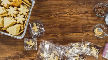 Düz yatıyordu. Dikkatlice paketlenmiş Noel kurabiyeleri, çikolataya batırılmış, ezilmiş fındık serpiştirilmiş, ve şeffaf selofan ambalajla sunulmuş..