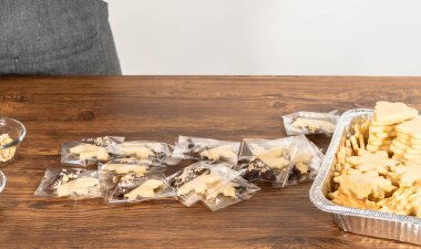 Dikkatlice paketlenmiş Noel kurabiyeleri, çikolataya batırılmış ve şeffaf selofan ambalajla sunulmuş, bayram hediyesi olarak mükemmel..